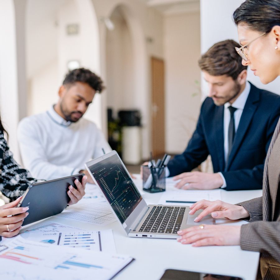 A diverse team collaborating with laptops in a modern office