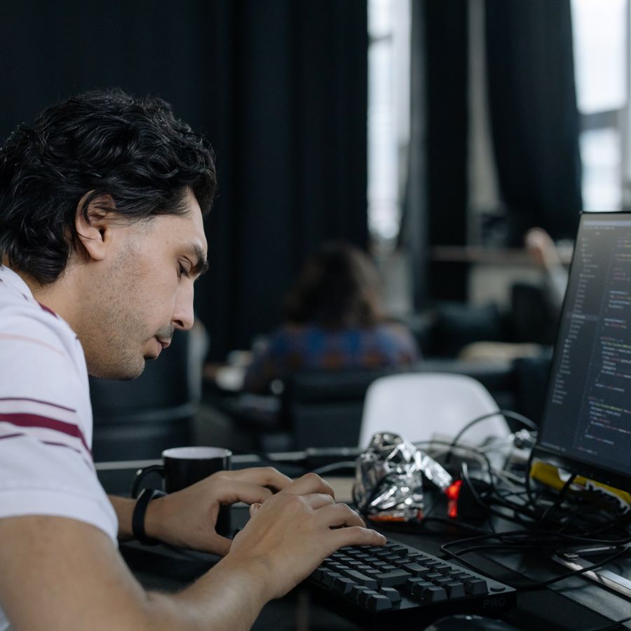 An engineer writing code at a multi-monitor workstation