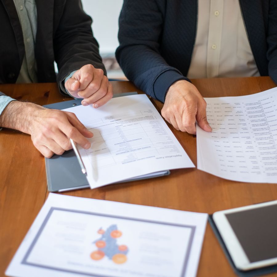 Professionals reviewing documents and reports at a table